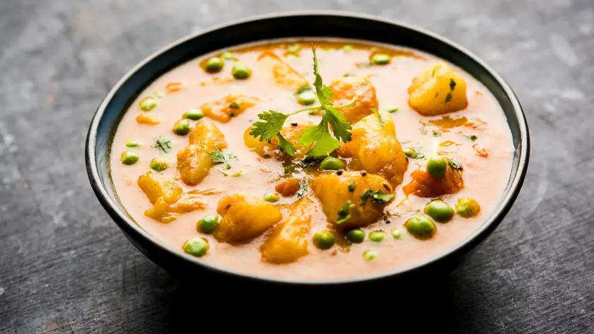 Indian Aloo Mutter curry featuring potatoes and green peas in rich onion tomato gravy, packaged as a retort ready-to-eat meal for commercial food brands.