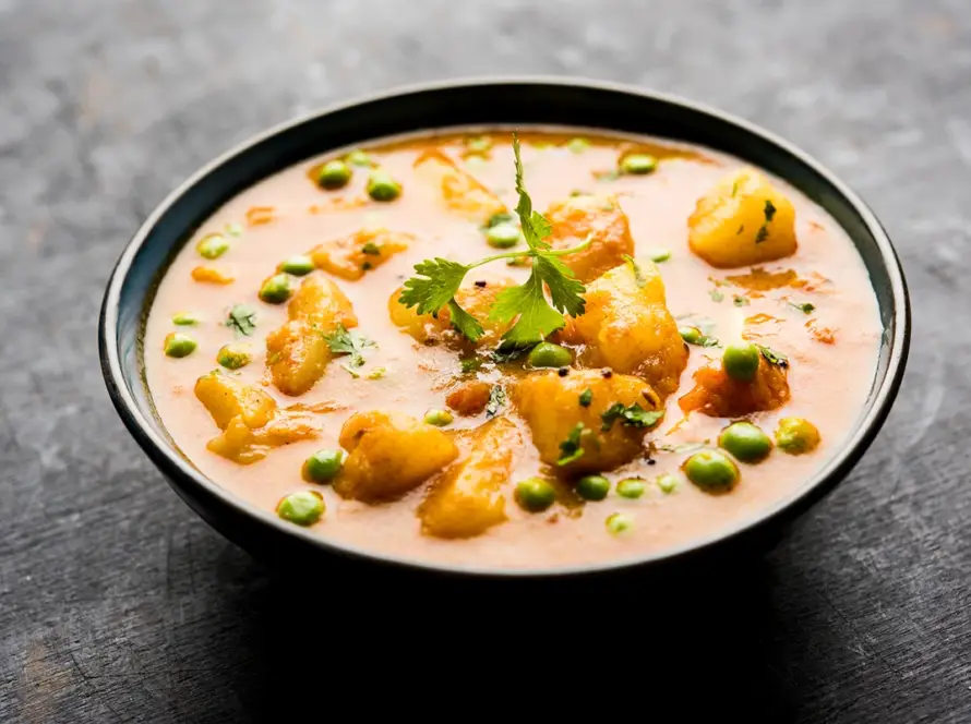 Indian Aloo Mutter curry featuring potatoes and green peas in rich onion tomato gravy, packaged as a retort ready-to-eat meal for commercial food brands.