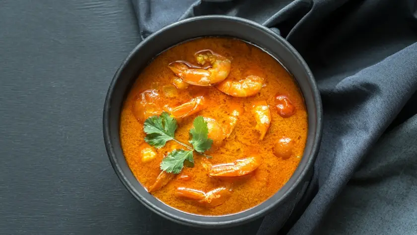 Bowl of Thai yellow curry with mixed seafood in creamy coconut sauce, suitable for retort ready-to-eat meal packaging and food brand development.