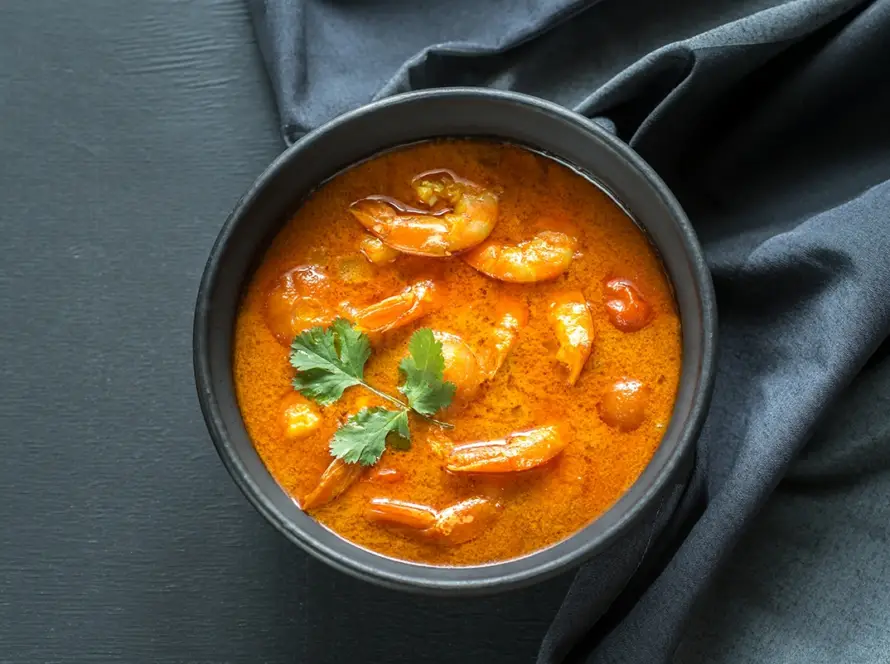 Bowl of Thai yellow curry with mixed seafood in creamy coconut sauce, suitable for retort ready-to-eat meal packaging and food brand development.