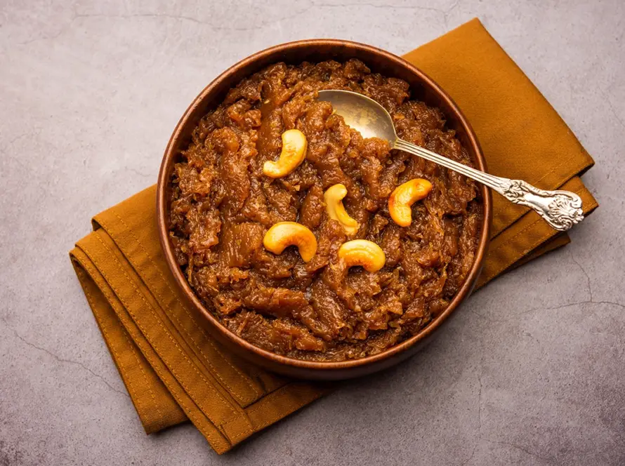 Top view of traditional Karnataka style Kashi Halwa made from ash gourd, garnished with cashews and saffron in a commercial serving pan.