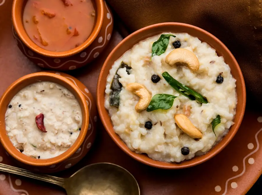 Top view of a South Indian breakfast spread featuring Ghee Pongal, Sambar, and Chutney in bowls, representing the B2B Early Bird Breakfast module.