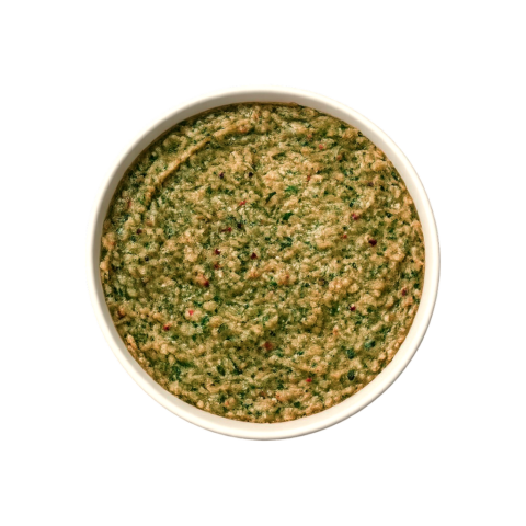 A professional 90-degree top-down flat lay of Pot and Ladle brand Bengaluru Donne Biryani Paste. The concentrated masala is a thick, textured, deep olive-green paste made from fresh mint, coriander, and green chilies. The surface shows a glossy sheen and visible bits of coarsely ground spices, served in a small white bowl on a seamless white studio background.