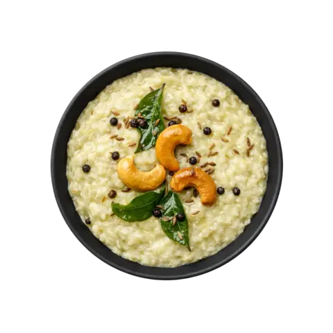 Ghee Pongal ready to eat with black pepper and cashews served in black bowl