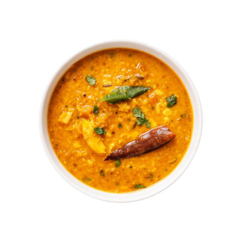 A professional 90-degree top-down shot of Pot and Ladle brand ready-to-eat Andhra Tomato Pappu. The vibrant yellow dal is slow-cooked with chunky red tomatoes and finished with a glossy tempering of mustard seeds, dried red chilies, and fresh curry leaves. Served in a minimalist white bowl on a seamless, pure white studio background.