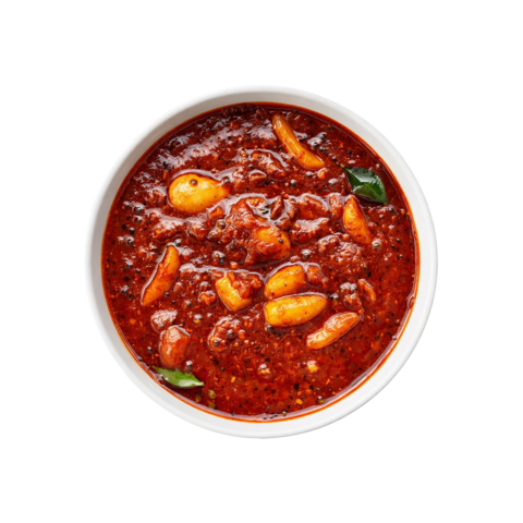 A professional 90-degree top-down flat lay of Pot and Ladle brand ready-to-eat Poondu Kuzhambu. The dish features a dark, concentrated tamarind-based gravy loaded with numerous whole, slow-cooked golden garlic cloves. The glossy, spice-flecked surface is tempered with mustard seeds and fresh curry leaves, presented in a minimal white bowl on a seamless white studio background.