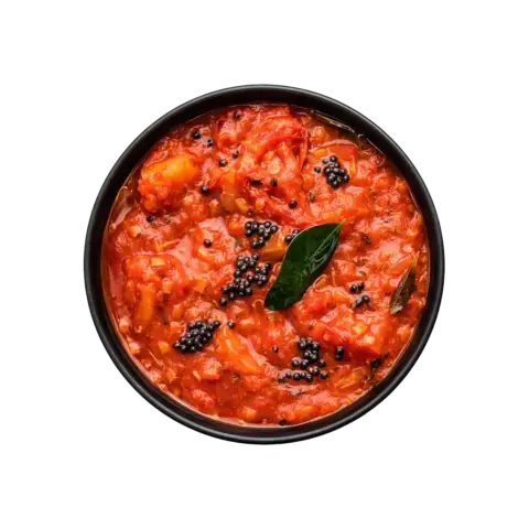 Top view of Pot & Ladle South Indian tomato gravy served in a smooth black china bowl, thick red tomato curry with mustard seeds and curry leaves on white background.