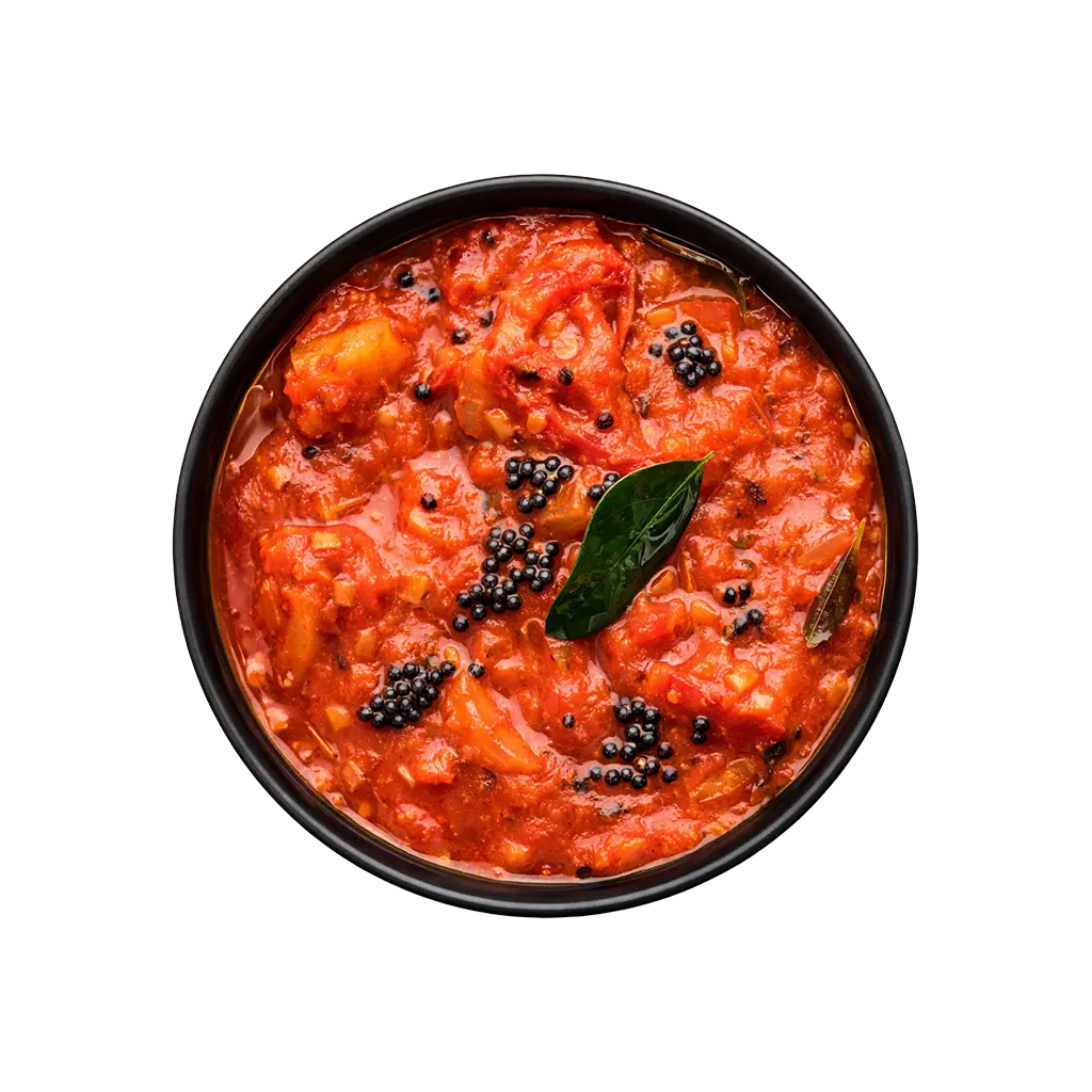 Top view of Pot & Ladle South Indian tomato gravy served in a smooth black china bowl, thick red tomato curry with mustard seeds and curry leaves on white background.